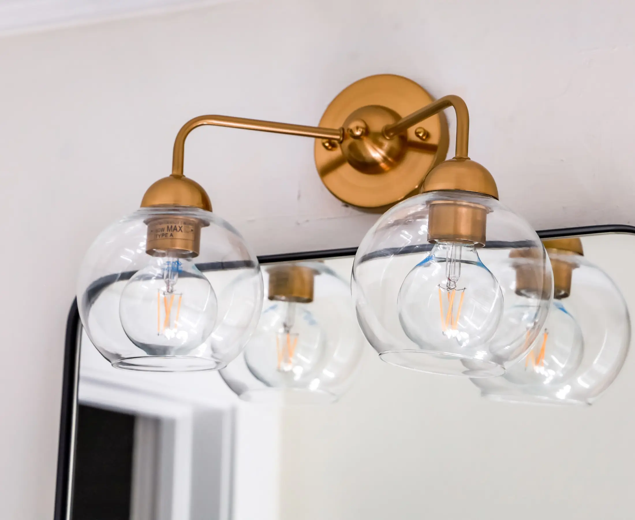 Gold wall light fixture with glass globes.