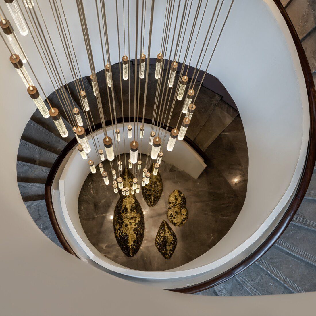 Spiral staircase with hanging pendant lights.